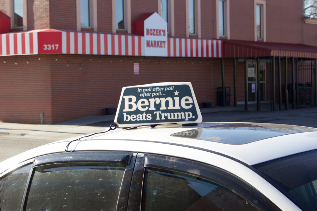 A vehicle display’s a pro-Sanders sign outside of a campaign office in Hamtramck.