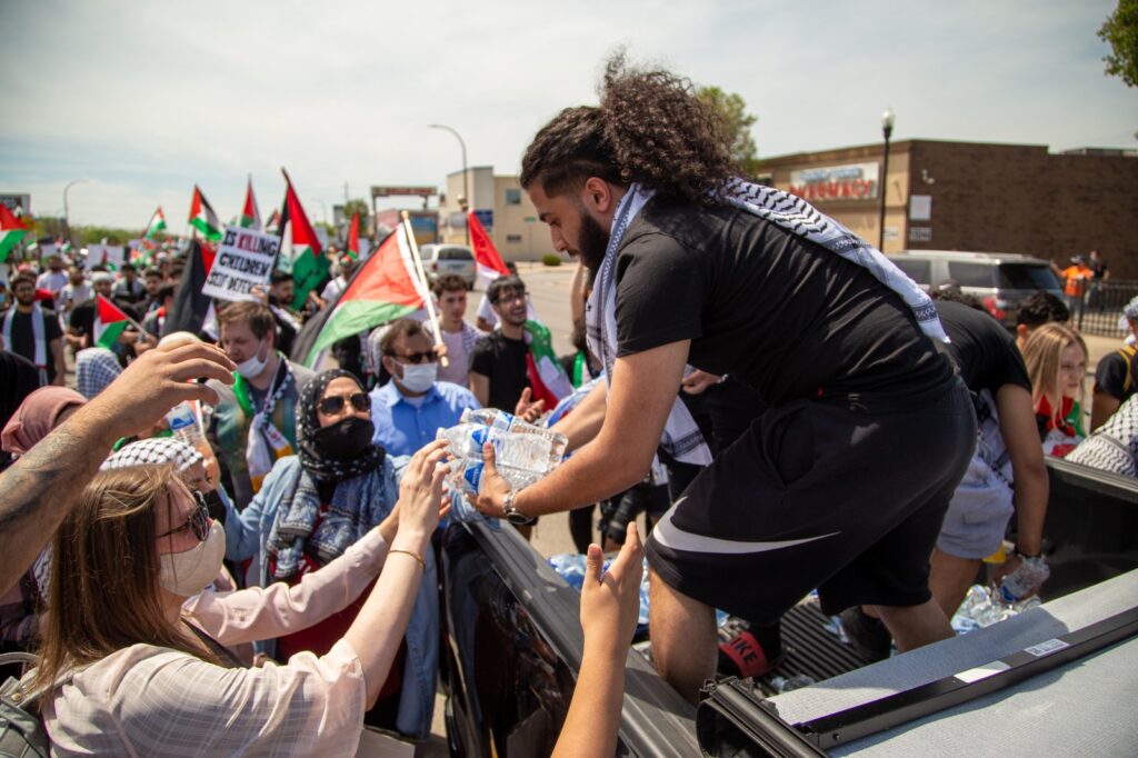 Volunteers hand out water bottles to protestors in Dearborn, Tuesday, May 19, on the occasion of President Biden's first visit to the city since being elected. Photo: Imad Mohamad/The Arab American News