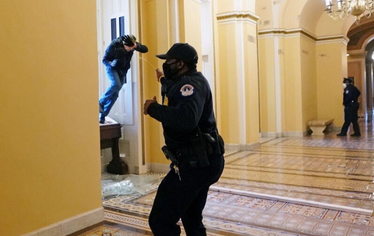 A U.S. Capitol police officer shoots pepper spray at a protestor attempting to enter the Capitol building during a joint session of Congress to certify the 2020 election results on Capitol Hill in Washington, U.S., Jan 6.