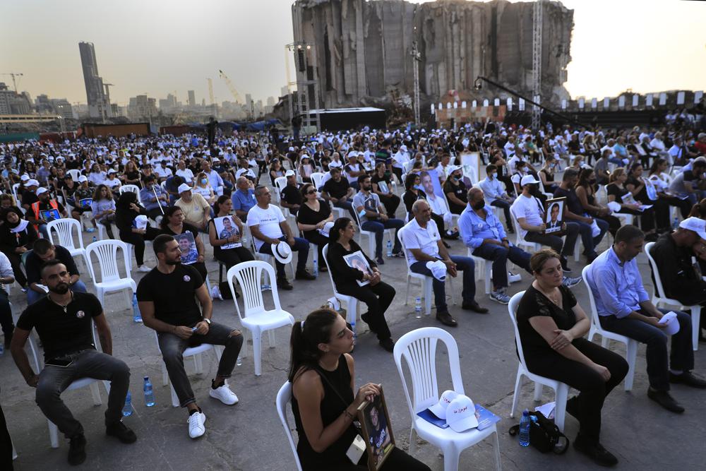 Relatives of victims who were killed in the massive blast last year at the Beirut port holds their portraits as they attend a Mass held to commemorate the first year anniversary of the deadly blast, at the Beirut port, Lebanon, Wednesday, Aug. 4. Photo: Hussein Malla/AP