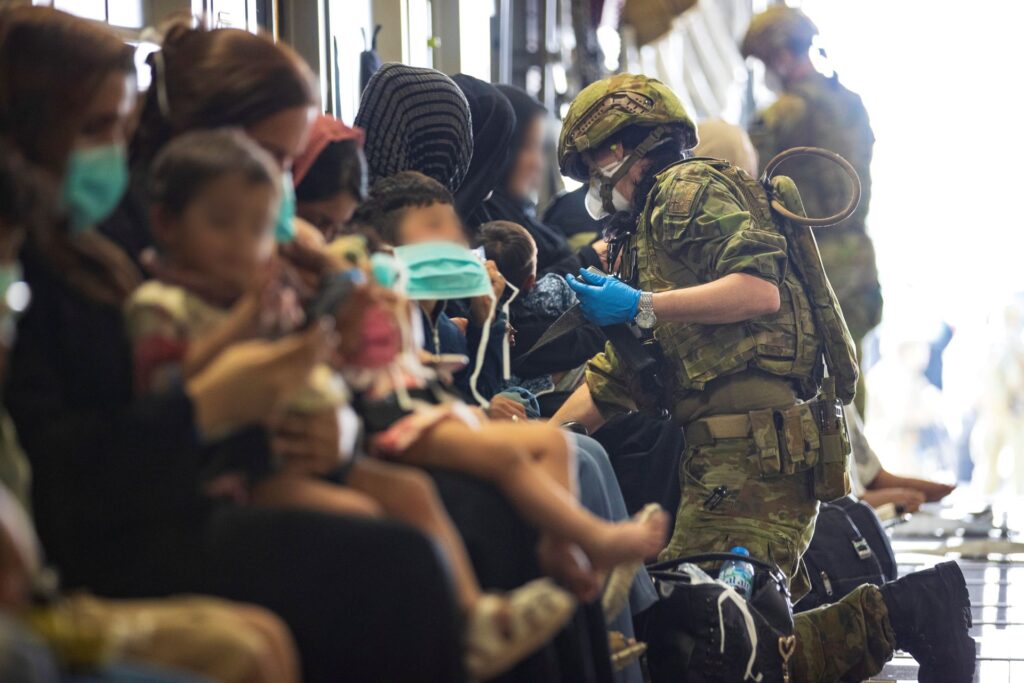 The Royal Australian Air Force Air Load Team assist evacuees into their seats on board the Royal Australian Air Force C-17A Globemaster III aircraft, prior to departing Hamid Karzai International Airport in Kabul, Afghanistan August 22. Photo: SGT Glen McCarthy/Australia's Department of Defense