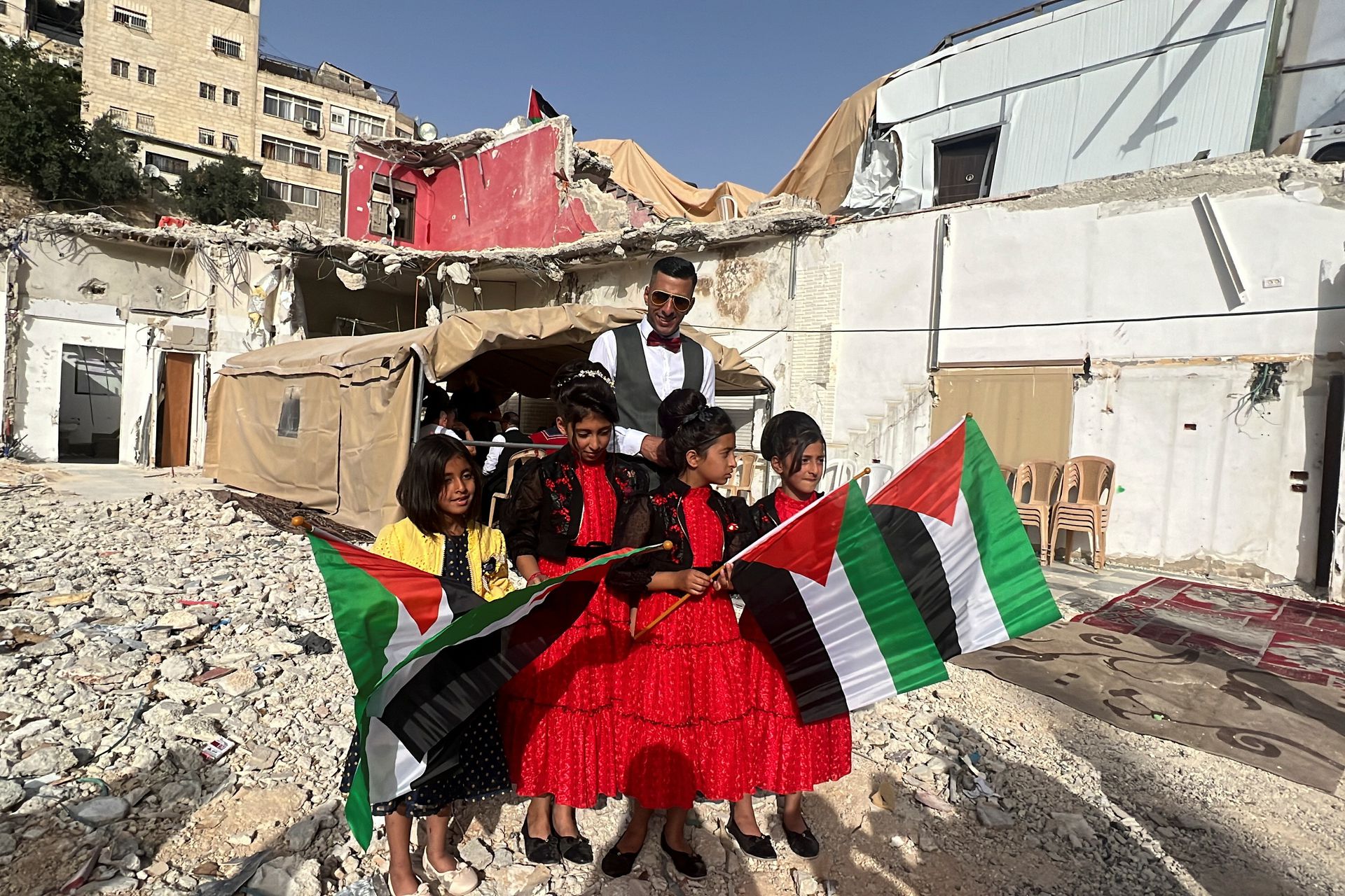Feras, brother of a Palestinian bride Rabeha Al-Rajabi, stands together with girls during a pre-wedding ceremony at the family's house, that was partly demolished by Israel authority, in East Jerusalem, June 11. Photo: Ammar Awad/Reuters
