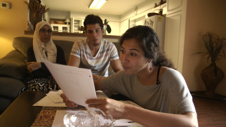 Assia Boundaoui shows FBI documents to her family in The Feeling of Being Watched.
