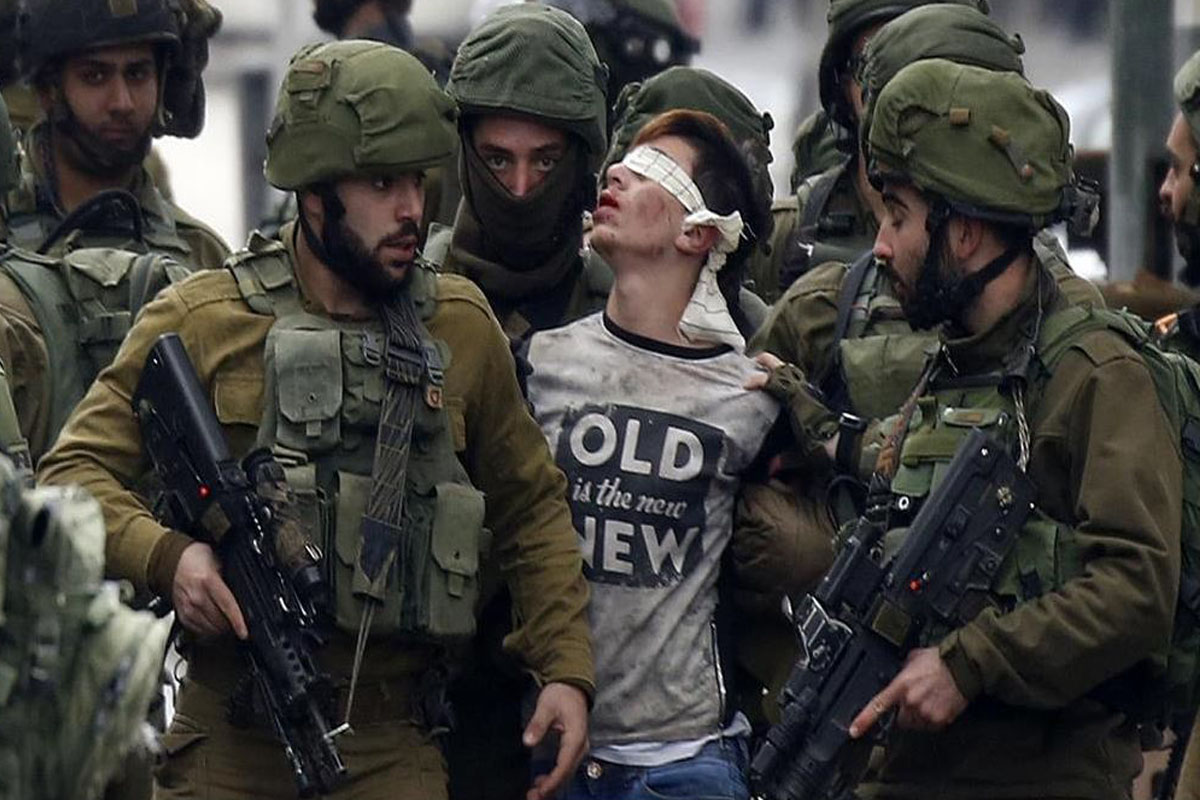 Israeli occupation soldiers while abducting Palestinian child Fawzi, 14, in occupied West Bank city of Al-Khalil.