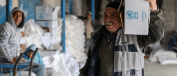 A Palestinian refugee receiving a food basket in the Al Shatti distribution center, Gaza City. Photo courtesy: UNRWA