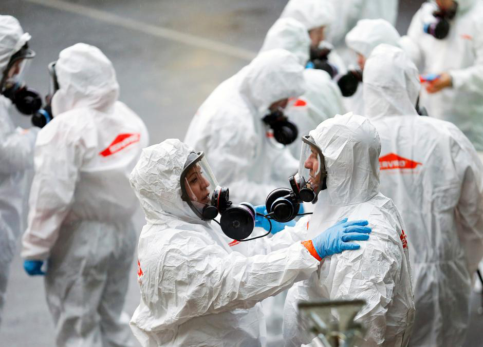A member of a Servpro cleaning crew checks a coworker's protective gear before entering the Life Care Center of Kirkland, a long-term care facility linked to several confirmed coronavirus cases, in Kirkland, Washington, U.S. March 12, 2020. REUTERS