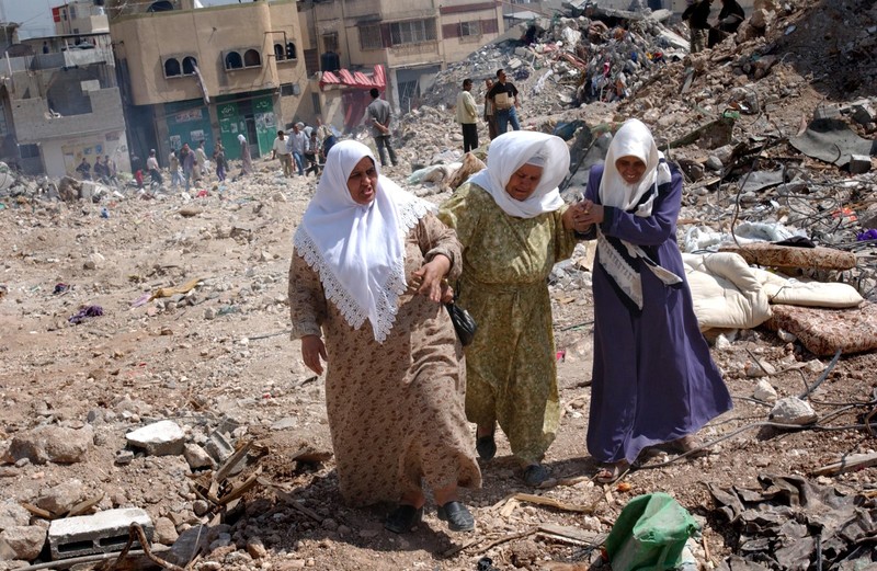 Women whose house was destroyed by the Israeli troops during fighting in the Jenin refugee camp, return to the rubble of their homes after the Israeli army pulled back to positions outside the camp April, 2002. Photo via KRT