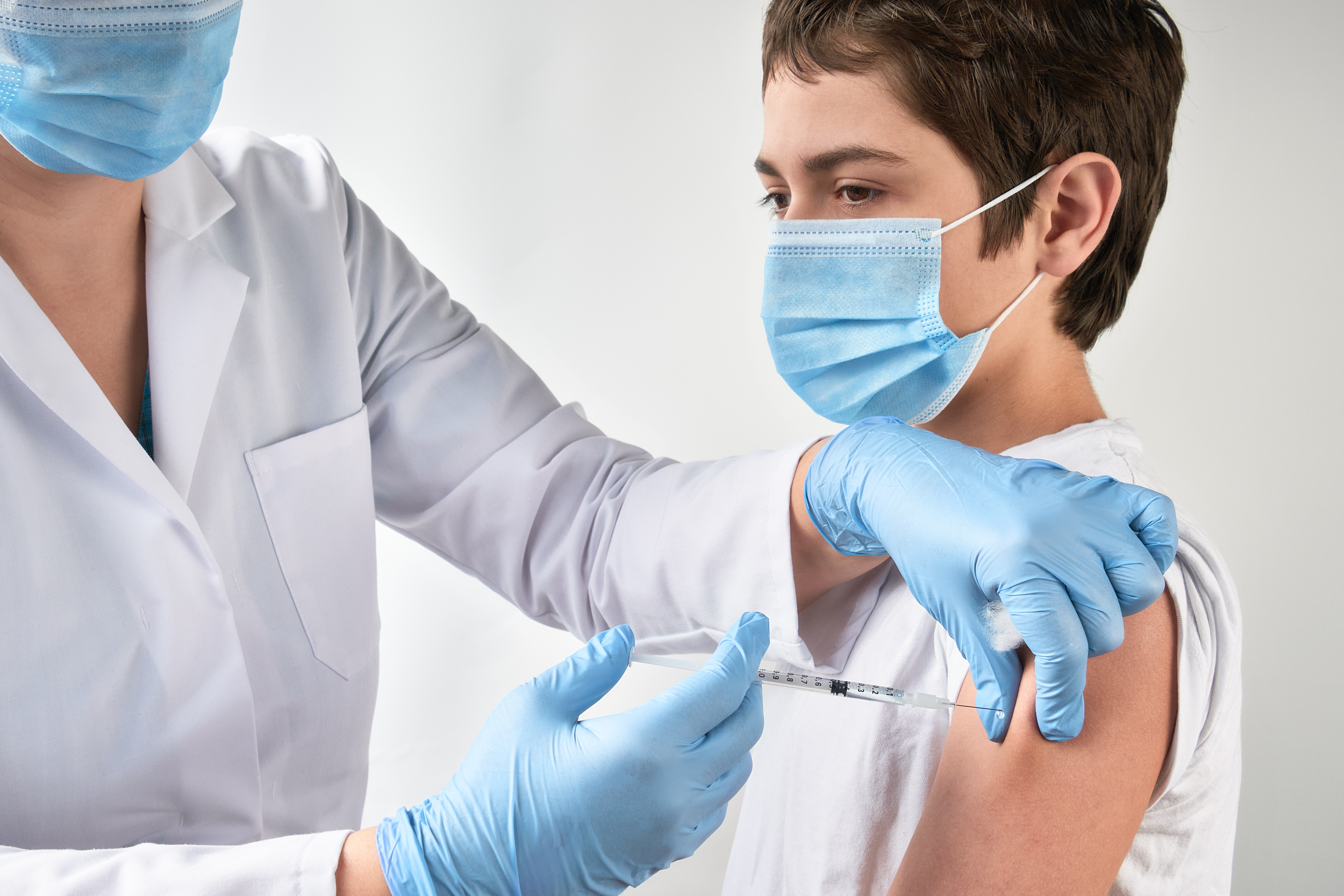 A teen gets a vaccine shot