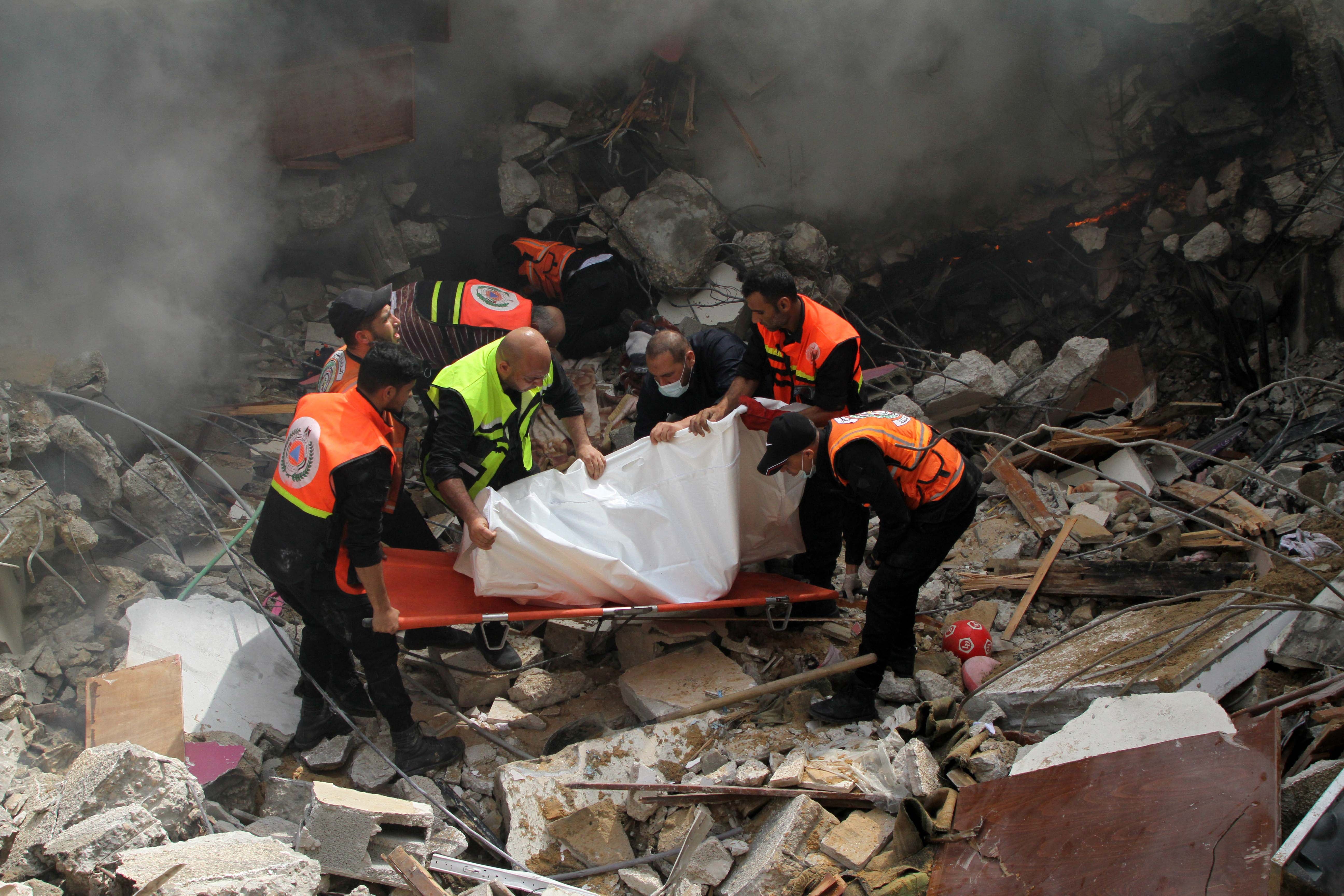 Members of the Palestinian civil defense remove the body of one of the 44 civilians killed after three multi-story residential buildings collapsed as a result of Israeli airstrikes in central Gaza City on May 16. Photo: Rizek Abdeljawad/HRW via Getty Images 
