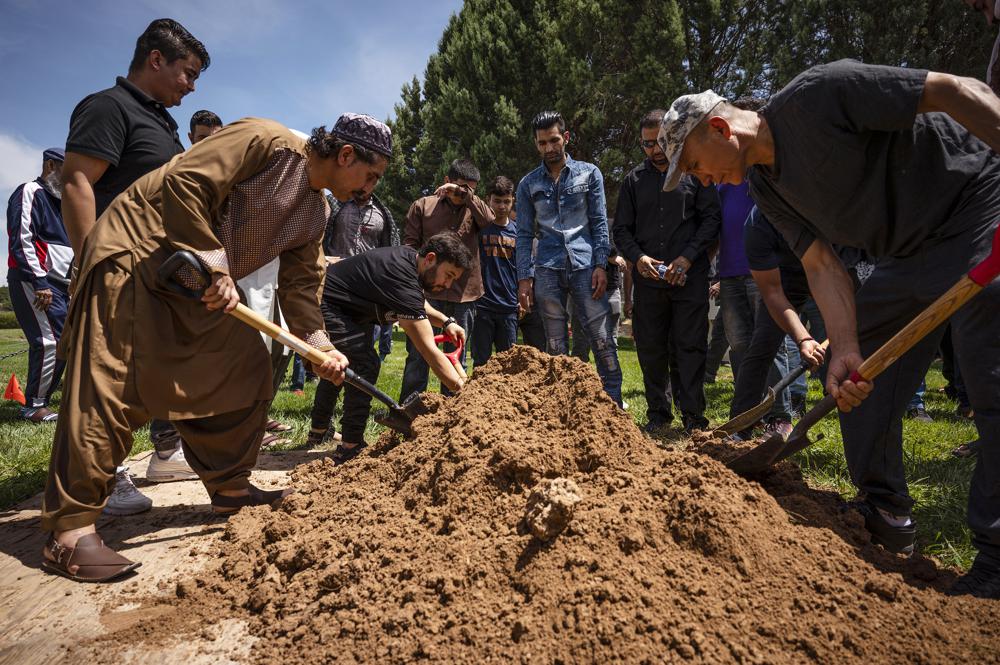 People spread dirt over Aftab Hussein's grave at Fairview Memorial Park in Albuquerque, New Mexico, on Friday, Aug. 5. Photo: Chancey Bush/The Albuquerque Journal via AP