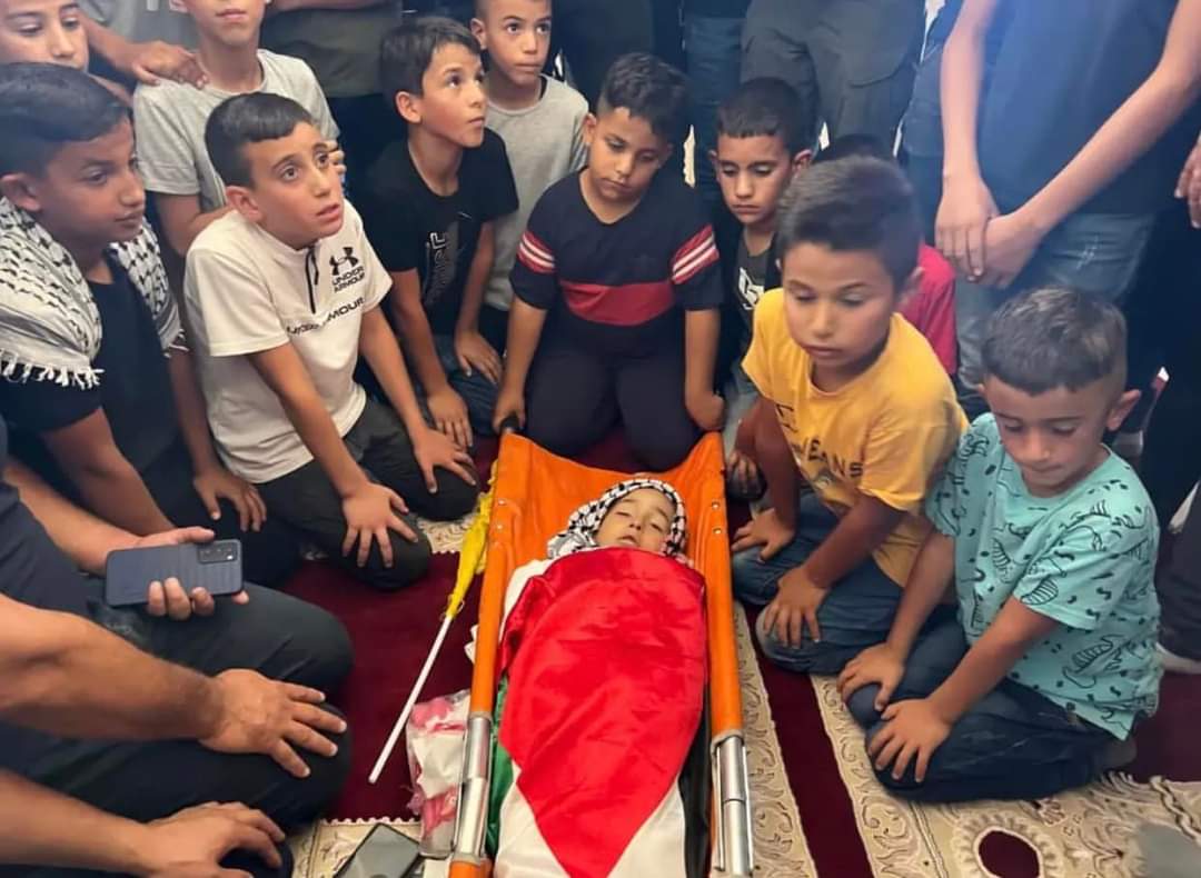 Loved ones surround the the body of Palestinian child, Rayan Suliman, 7, who died after his heart stopped beating out of fear while being chased by Israeli occupation forces in Tuqu village in the occupied city of Bethlehem In September. Photo via Twitter