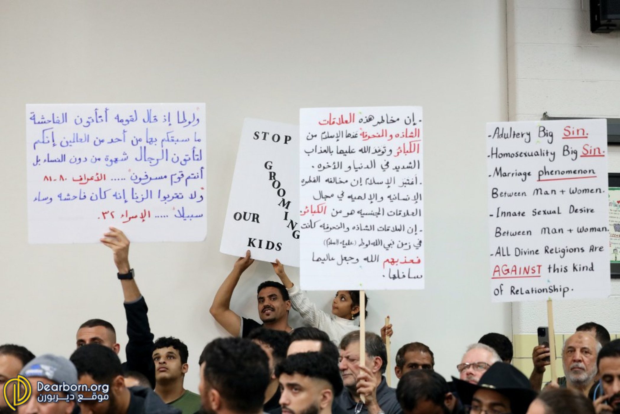 Protestors hold signs at the Dearborn Public Schools Board of Education meeting on Monday, Oct. 10 before it was shutdown by Dearborn Police and Fire, to be reconvened later in the week. Photo: Dearborn.org